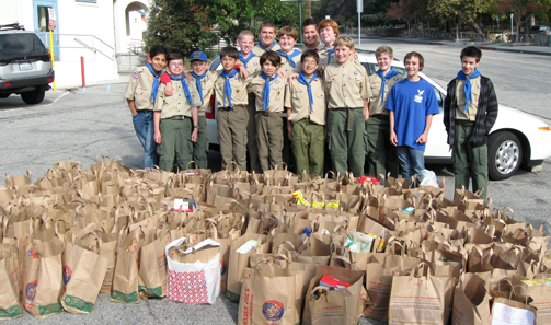  Scouts of Troop 319 gather behind all of the food they collected from area neighborhoods for local food banks. Photo by Chris BLUME