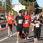 Runners turn the corner toward the finish line at the Thanksgiving Day Run and Food Drive in La Cañada on Thanksgiving day.