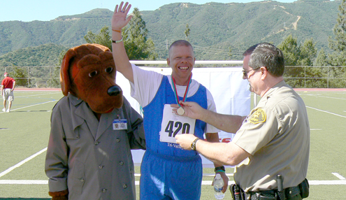 At the 2010 Special Olympics at CV High School, Capt. Dave Silversparre pinned a medal onto an athlete as McGruff looks on. 