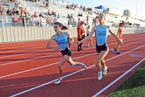 Kayleigh Carrillo taking the baton from Cali King in the 4x400m relay.