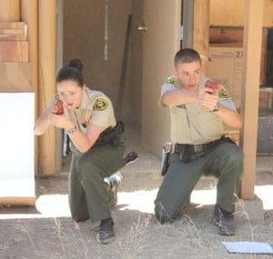 Explorers Shannon Snyder and Kevin Lentz are shown with simulated guns drawn during a competition.