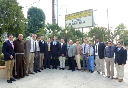Nolan (sixth from left), shown with students and staff of St. Francis, visited the campus on Monday to talk about the news business at a morning presentation.