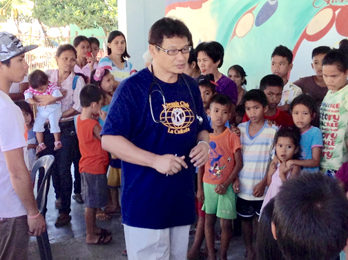Dr. Edgio Elio, wearing a Kiwanis Club of La Cañada T-shirt, greets patients at the Tabang “Help” Antique Philippines Medical Mission.