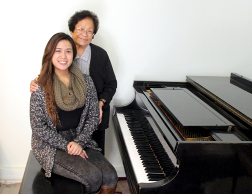 Music teacher Celia Celis, standing, helped deaf student Mara Ladines master the piano.