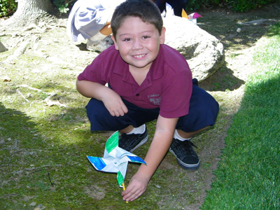 Searching for his place }}} Ethan Aellano plants his peace pinwheel on the school grounds.