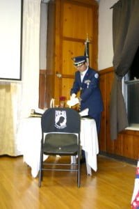 Photos by Natalie MAIER Cadet First Lt. Kevin Yang lights the candle on the POW/MIA table.