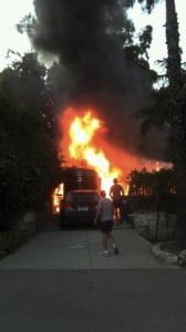 Ray Harley front and Mike Leum toward fire, both from LASD, respond to help resident whose vehicle was a blaze.