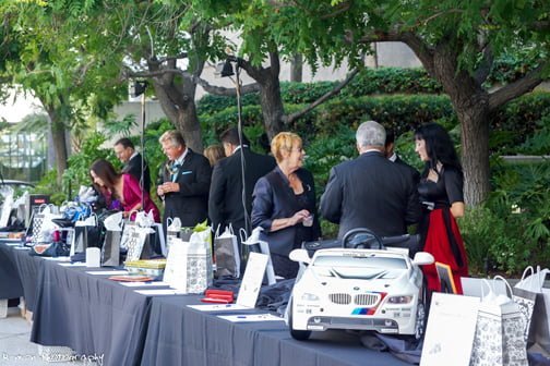 Guests mingle while gathered around the tables loaded with donated items for the silent auction.