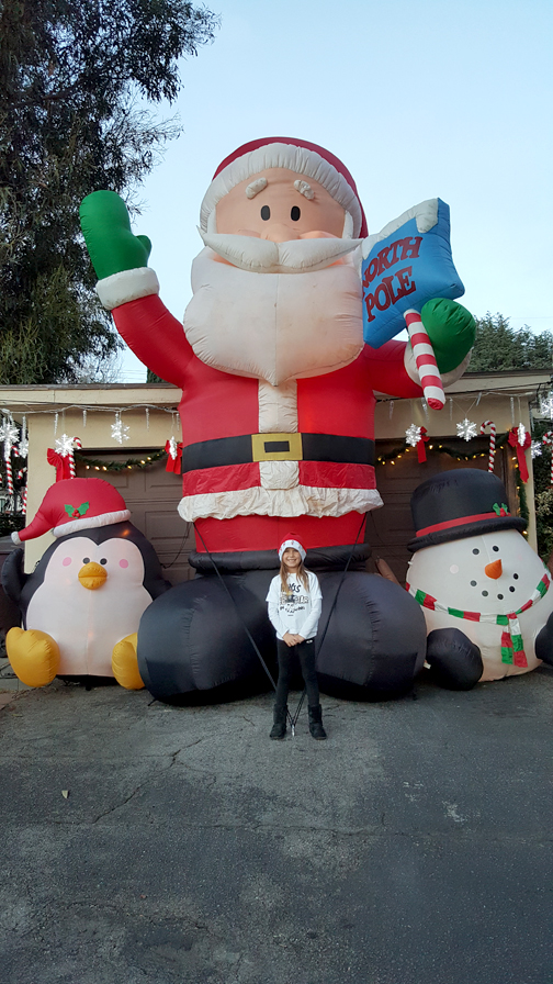 The Fisher home in the 4400 block of New York Avenue is full of eye-catching details and includes a giant inflatable Santa that 7-year-old Annika Mark, a student at La Crescenta Elementary, is standing in front of. 